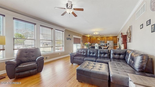 living area featuring a ceiling fan, visible vents, ornamental molding, and light wood-style flooring