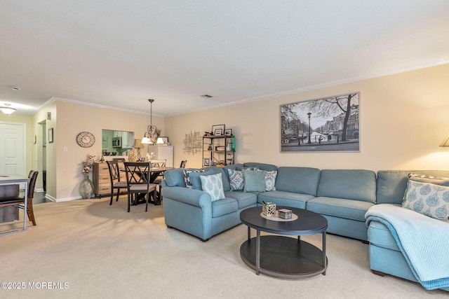 living area featuring light colored carpet, ornamental molding, a chandelier, and visible vents