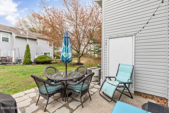 view of patio featuring central AC unit and outdoor dining area
