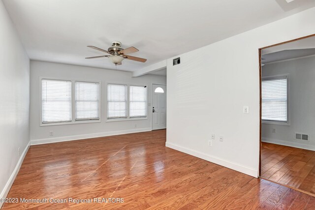 unfurnished living room with a ceiling fan, baseboards, visible vents, and light wood finished floors