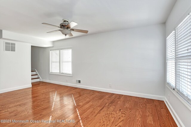 unfurnished room with baseboards, a ceiling fan, light wood-style flooring, and visible vents