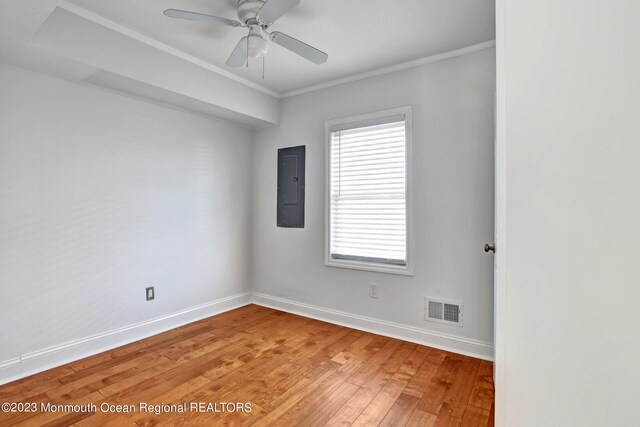 spare room with light wood-style floors, visible vents, a healthy amount of sunlight, and electric panel