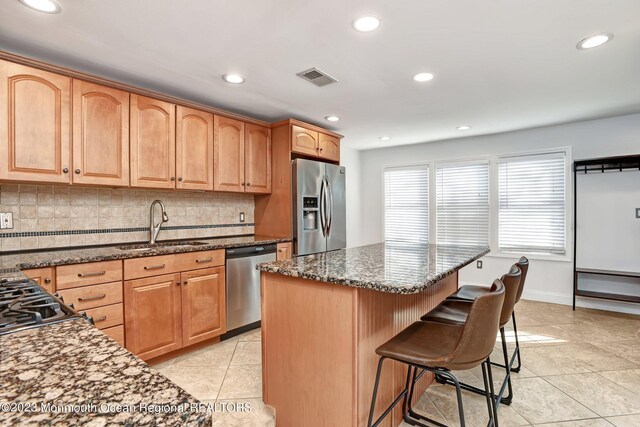 kitchen featuring a sink, stainless steel appliances, decorative backsplash, light tile patterned floors, and visible vents