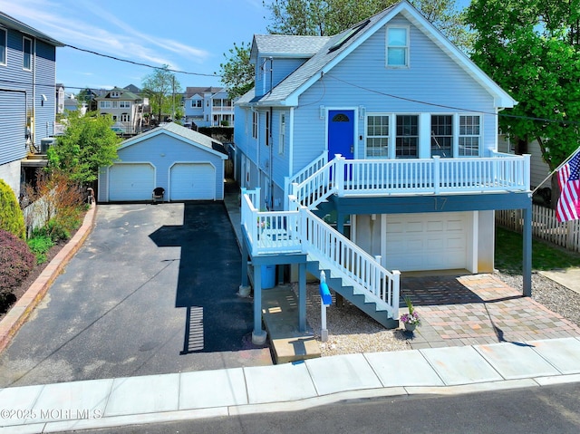 view of front of property featuring a garage, an outdoor structure, stairway, and a residential view