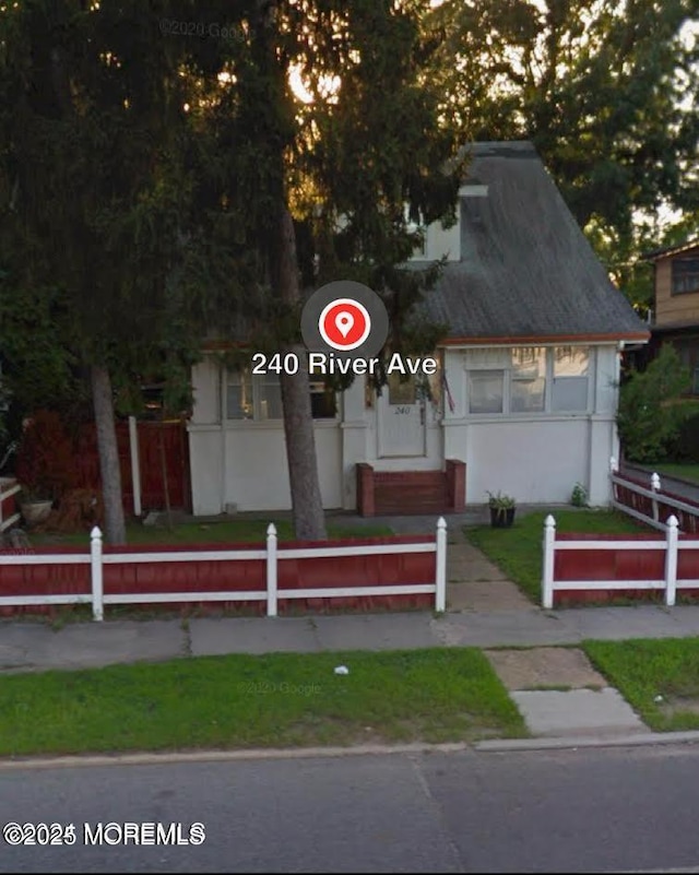 view of front facade featuring fence and stucco siding