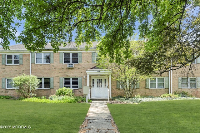 colonial home featuring brick siding and a front lawn