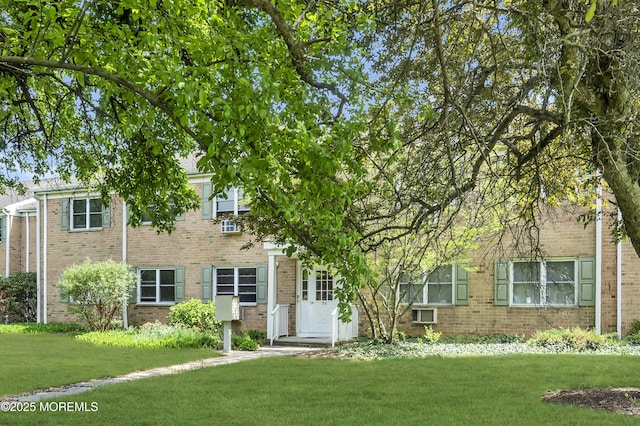 view of front of house with brick siding and a front lawn