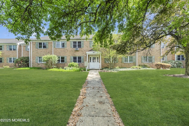 view of front of property featuring brick siding and a front lawn