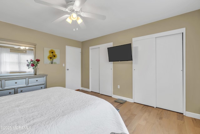bedroom with multiple closets, baseboards, a ceiling fan, and light wood-style flooring
