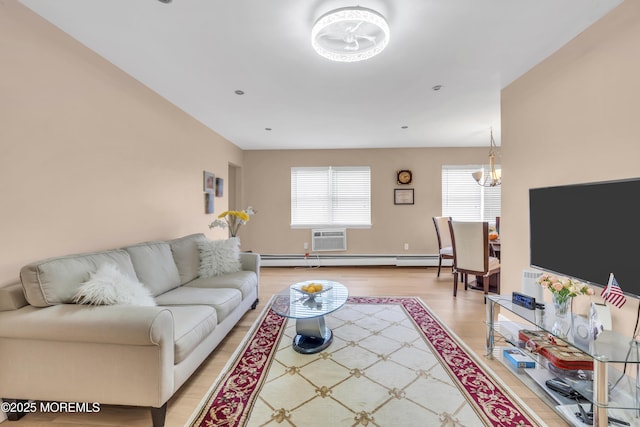 living area with a wall mounted air conditioner, an inviting chandelier, baseboard heating, and light wood-style floors