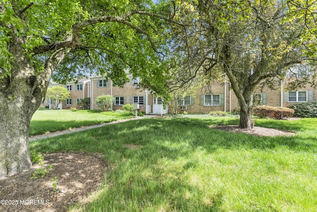 view of front of property featuring brick siding and a front lawn