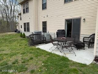 back of house with a lawn and a patio