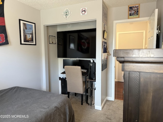 carpeted bedroom featuring baseboards and a textured ceiling