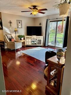 living area with a ceiling fan and wood finished floors