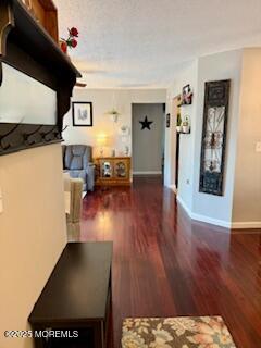 hall featuring baseboards and wood finished floors