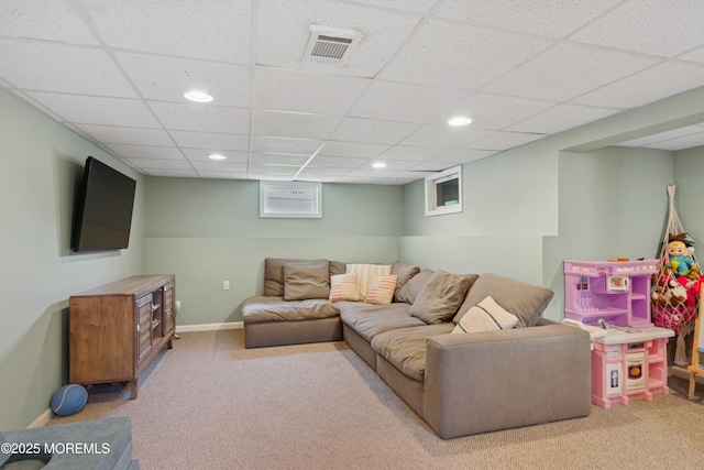 living room with a drop ceiling, visible vents, recessed lighting, and carpet floors