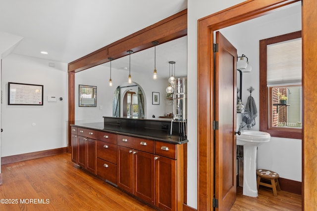 bathroom with a sink, baseboards, and wood finished floors