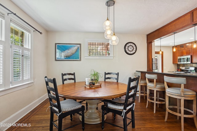 dining area featuring dark wood-type flooring and baseboards