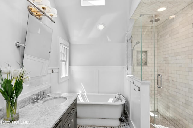 full bathroom with a wainscoted wall, a shower stall, vanity, and a freestanding tub