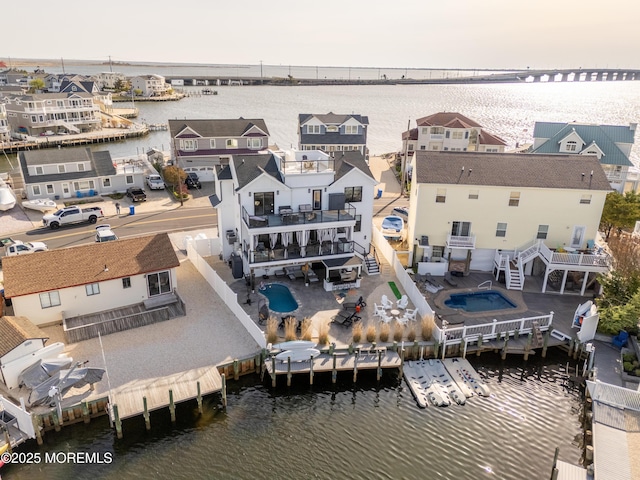 birds eye view of property with a water view and a residential view