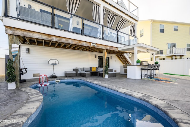 view of swimming pool featuring outdoor dry bar, stairs, an outdoor hangout area, a fenced in pool, and a patio
