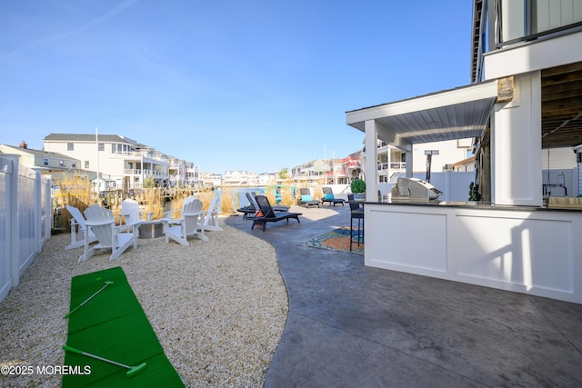 exterior space with fence, a patio area, area for grilling, and a residential view