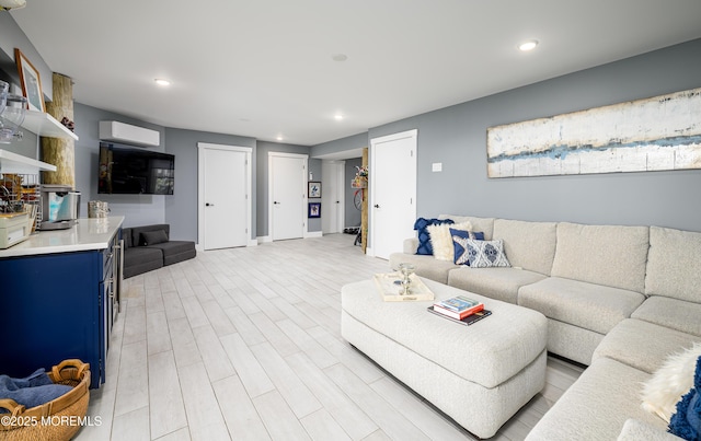 living room with light wood-style floors, an AC wall unit, and recessed lighting