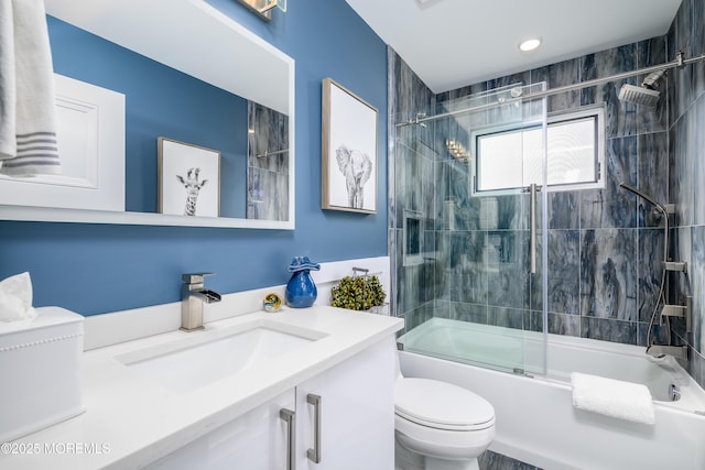 bathroom featuring toilet, enclosed tub / shower combo, and vanity