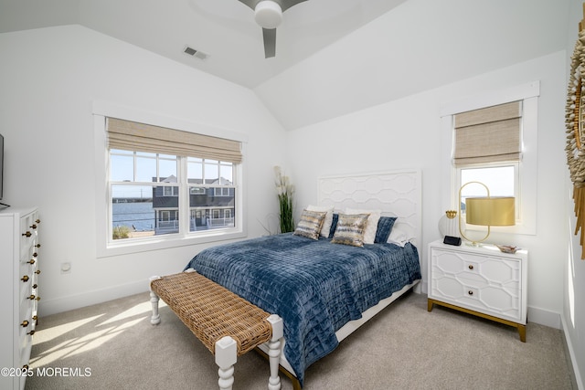 carpeted bedroom featuring multiple windows, vaulted ceiling, ceiling fan, and visible vents