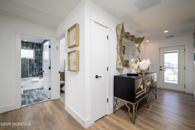 hall with recessed lighting, visible vents, and wood finished floors
