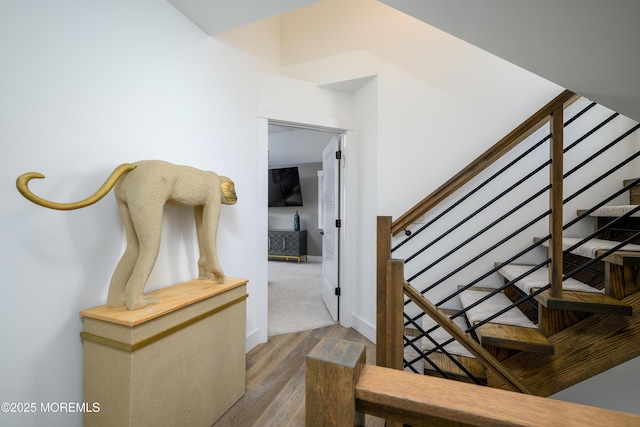 staircase featuring baseboards and wood finished floors