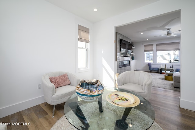 living area featuring baseboards, recessed lighting, and wood finished floors
