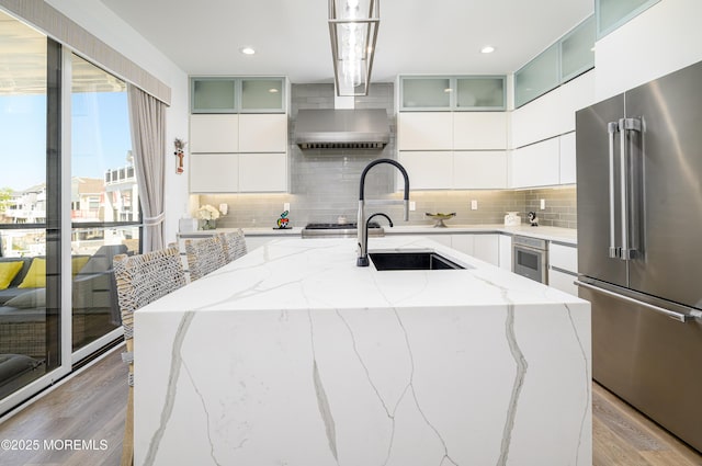 kitchen featuring light wood-style floors, appliances with stainless steel finishes, modern cabinets, and backsplash