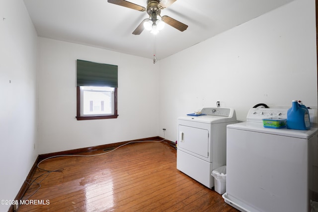 clothes washing area featuring washing machine and clothes dryer, laundry area, ceiling fan, wood-type flooring, and baseboards