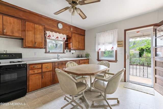 kitchen featuring light countertops, plenty of natural light, range with gas stovetop, and ceiling fan