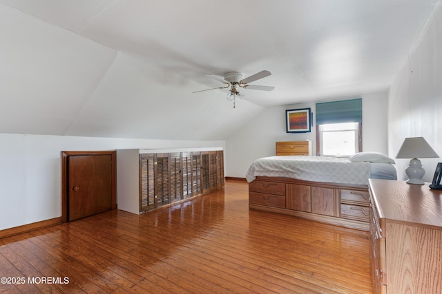 bedroom with baseboards, a ceiling fan, lofted ceiling, and hardwood / wood-style flooring