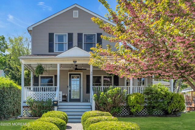 view of front of home featuring a ceiling fan, a porch, and a front lawn