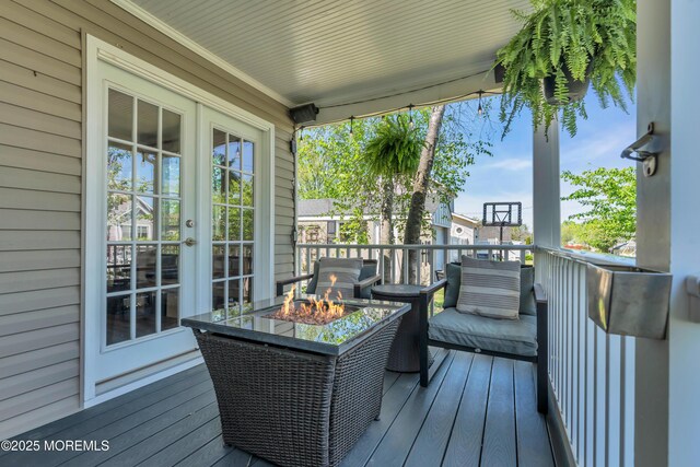 wooden deck with an outdoor fire pit and french doors