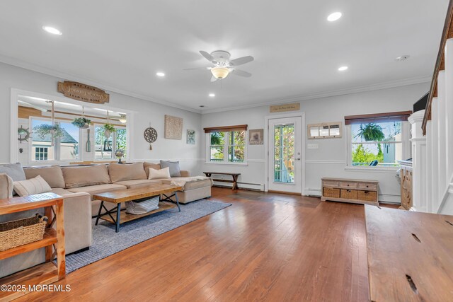 living area featuring wood finished floors, a ceiling fan, baseboard heating, and a baseboard radiator