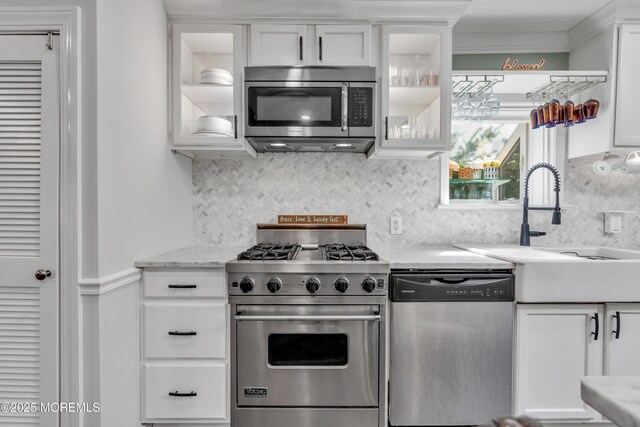 kitchen featuring a sink, appliances with stainless steel finishes, white cabinets, and glass insert cabinets