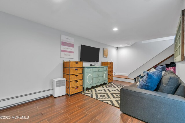 living room featuring baseboard heating, dark wood finished floors, recessed lighting, baseboards, and stairway