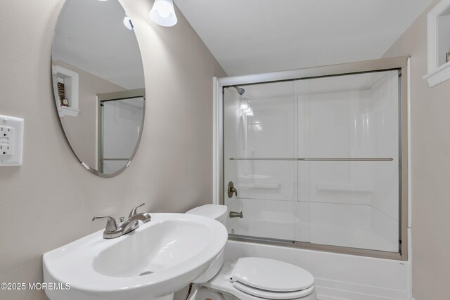 bathroom with shower / bath combination with glass door, a sink, and toilet
