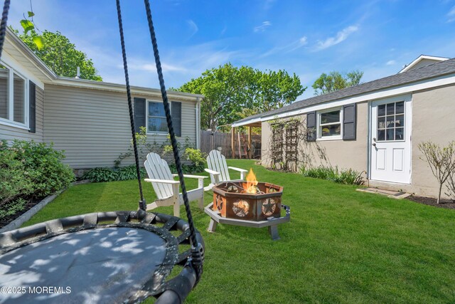 view of yard with fence and an outdoor fire pit