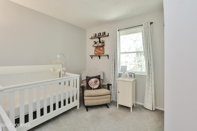 bedroom featuring light colored carpet and a nursery area