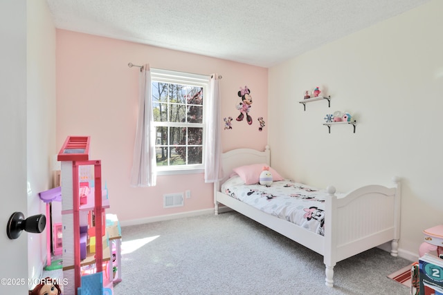 carpeted bedroom with visible vents, a textured ceiling, and baseboards