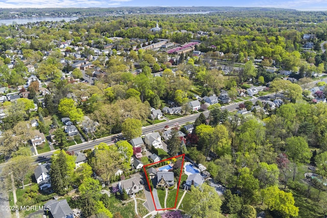 bird's eye view featuring a water view, a residential view, and a wooded view