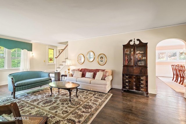 living area featuring baseboards, ornamental molding, stairs, and wood finished floors