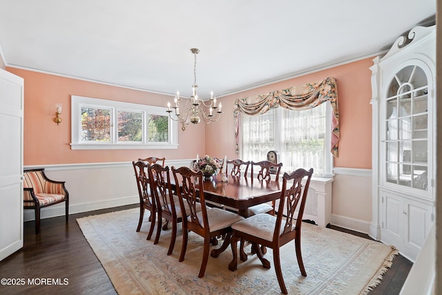dining room with crown molding, an inviting chandelier, plenty of natural light, and wood finished floors