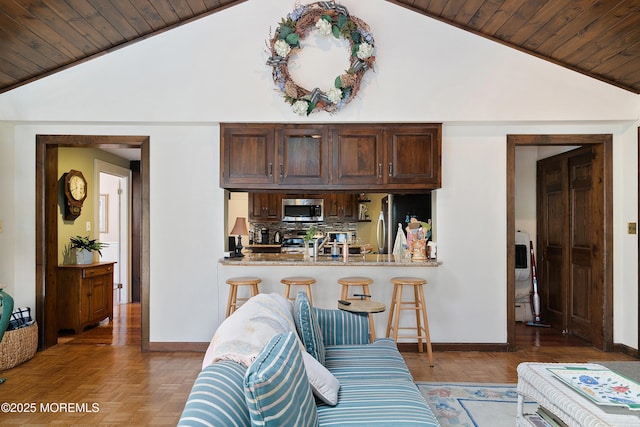 living area featuring baseboards, wood ceiling, and lofted ceiling