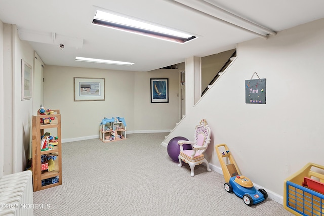 rec room with baseboards and carpet flooring